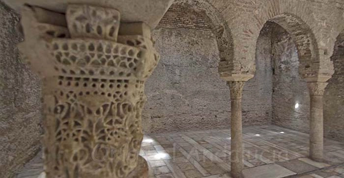 Het interieur van de Moorse hammam El Bañuelo met hoefijzerbogen, Byzantijnse pilaren en stervormige lichtopeningen in Granada